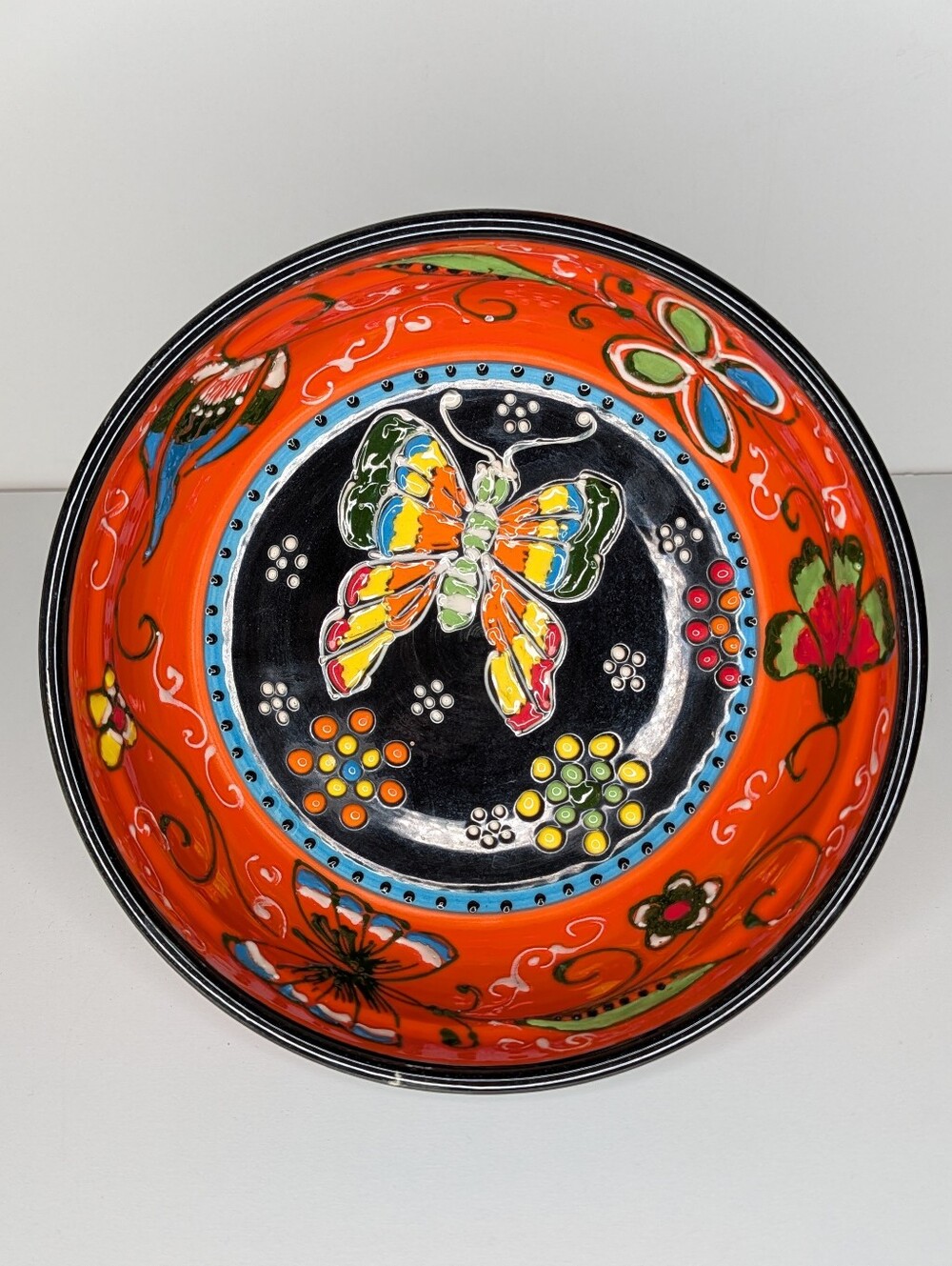 Handmade ceramic bowl with colorful butterfly and floral design. Made in Spain.